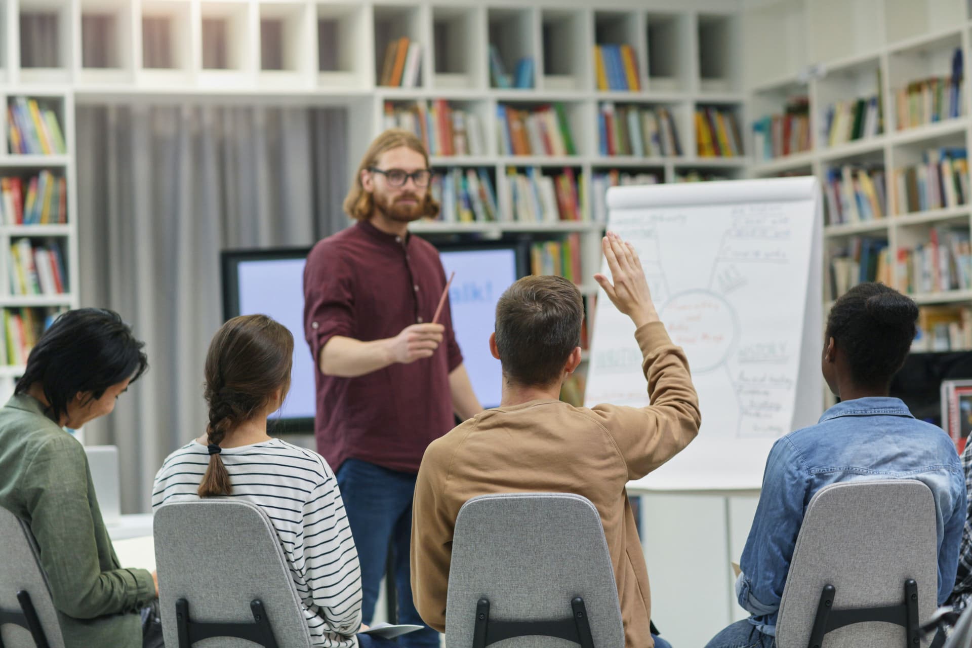 Teacher facilitating a discussion with teenage ESL students